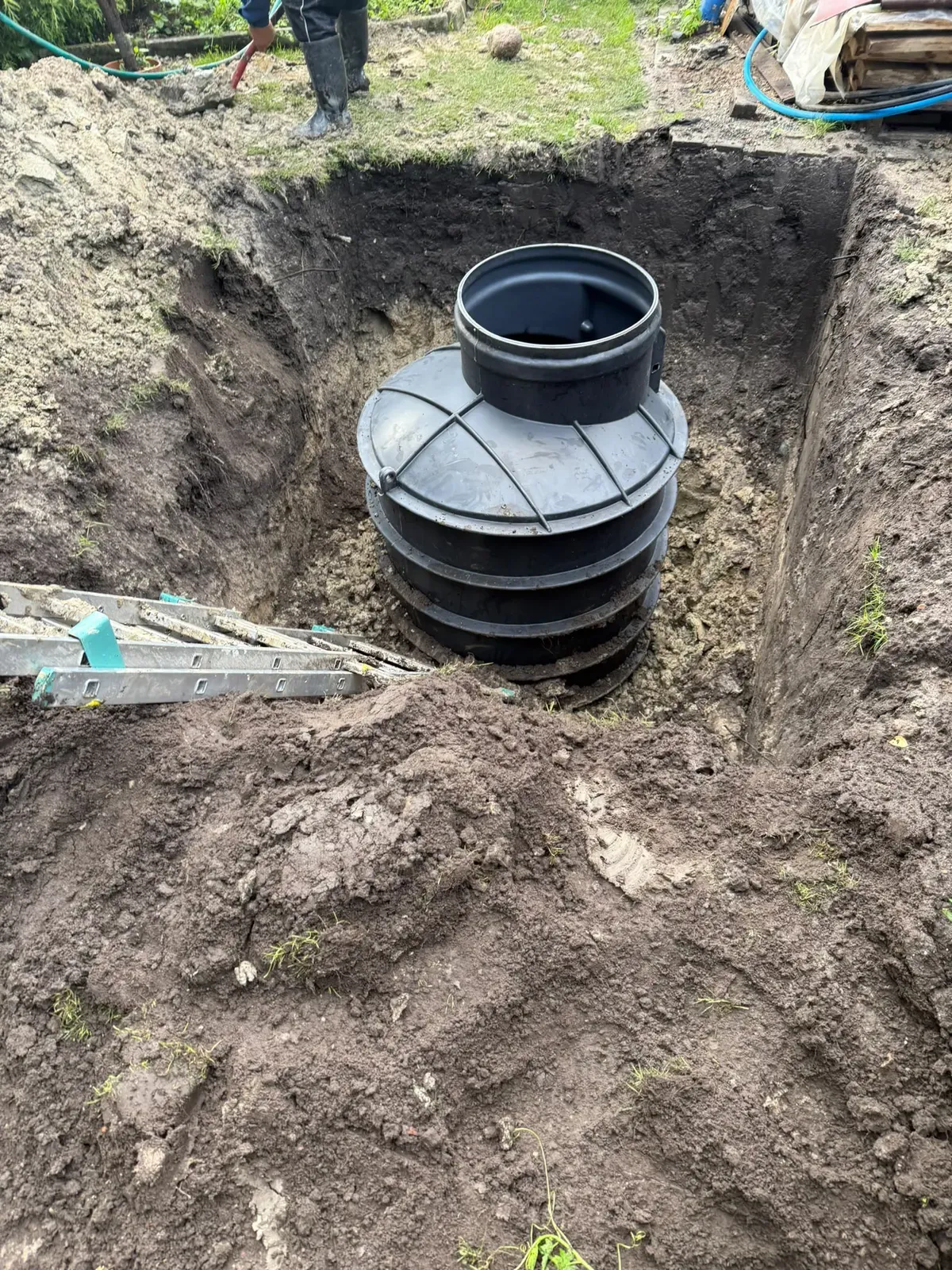 Czarna obudowa studni głębinowej w głębokim wykopie